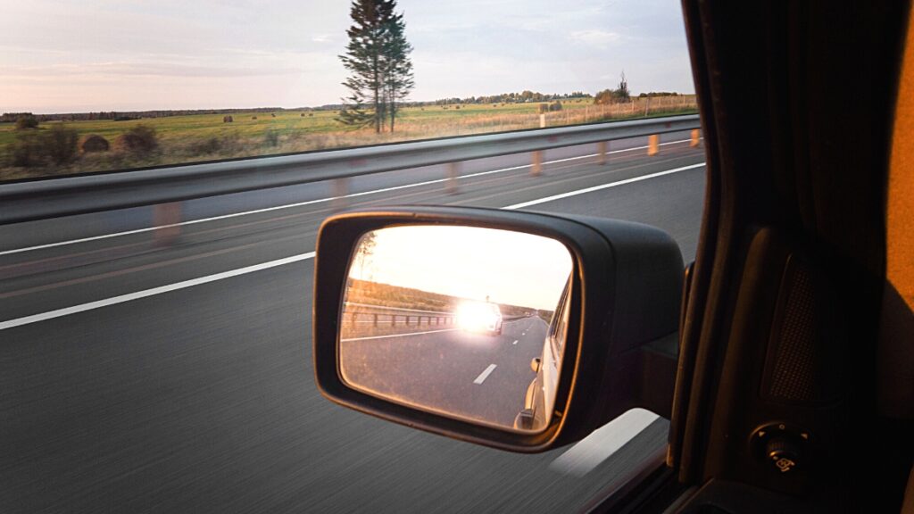 Memperhatikan kaca spion merupakan contoh tips aman berkendara mobil